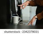 Closeup business woman using coffee machine in the office.