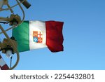 Small photo of An Italian tricolour defaced with a variant of the arms of the Italian Navy and without a mural crow on the wind hanging on the navigational mast with lights and radar on merchant container vessel.