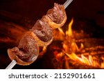 Small photo of Picanha barbecue roasted on the spit on the coals. This type of barbecue is widely consumed throughout Brazil