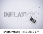Small photo of Word hand writing INFLATION is deleted by black FED eraser on white paper background copy space. The Federal Reserve ( FED ) increase % interest rates to fix inflation crisis. World economy concept.