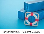 Lifebuoy with blue containers on blue background with copy space. Marine cargo shipment or freight insurance in global shipping and logistic industry. Insurance is risk management control.