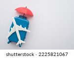 Travel insurance business concept. Red umbrella cover airplane and suitcases on white background. Travel insurance covers loss suitcase, flight delays, cancellations, accident and medical expenses.
