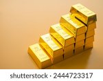 Stack gold bars as rise up stairs on yellow background. Gold price increase, investment in commodity market trading, etf, risk mnagement concept. Gold is safe haven in economy crisis, war.