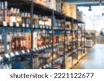 Small photo of Blur shelves with wine bottles at liquor store as background with copy space. Many blurred bottles with alcohol