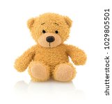 Small photo of Cute bear doll isolated on white background with shadow reflection. Playful bright brown bear sitting on white underlay. Stuffed teddy bear on white backdrop.