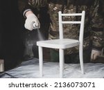 A man repairs old furniture.paints a children's chair with spray paint. handmade concept