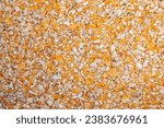 Small photo of Crushed corn seed background, top view. Dry and crushed corn seeds, background, texture, top view. Pile of crushed corn seeds. Background from crushed corn seeds, texture.