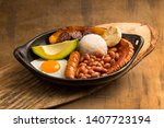 Small photo of Bandeja paisa, typical dish at the Antioquena region of Colombia. It consists of chicharron (fried pork belly), black pudding, sausage, arepa, beans, fried plantain, avocado egg, and rice