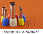 Small photo of Coloured crimp terminals for different wire sizes. Copper sleeves for crimping electrical cables. Ferrules. Selective focus, copy space