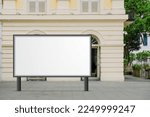 Large horizontal blank advertising poster billboard banner mockup in front of building in urban city; digital light box display screen for OOH media. 12 sheet out-of-home
