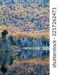 Small photo of Autumn beauty in White Mountain National Forest. Reflection of hillside with colorful fall foliage on calm surface of Beaver Pond in Kinsman Notch, New Hampshire.