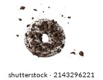 White chocolate glazed donut with dark cookies crumbs and creme filled closeup flying. Sweet doughnut falling isolated on white background