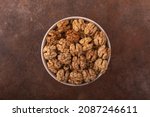 Beautiful kernels of peeled walnuts in a light bowl on a vintage rusty background. The concept of the beneficial properties of walnuts. Various forms of walnuts, preparation for baking.