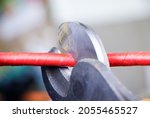 Small photo of Cutting pliers and cable. A cutter is cuting electrical wire or cable. Cutting wires with clippers.Metal nippers.