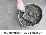 Mixing of concrete mortar.The builder prepares the cement mortar using a construction trowel.Plaster mortar in a bucket.