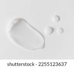 Small photo of White beauty cream smear smudge and serum drops on white background. Cosmetic skincare product texture. Face cream, body lotion swipe swatch