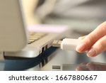 Close up of woman hands connecting usb flash drive on a laptop computer