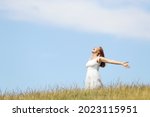 Excited woman screaming to the air outstretching arms in a wheat field