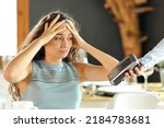 Small photo of Worried woman complaining about expensive restaurant bill