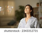 Satisfied woman breathing sitting at home in the night