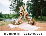 Small photo of Wedding boho arch decorated with flowers for ceremony against the forrest landscape. wedding ceremony in boho style. Outdoor party