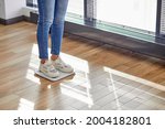 Small photo of Weight loss. Cropped slim lady standing on weighing scale, checking weigh at home, smart weigh scales help woman to keep fit, to monitor weight