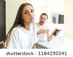 Small photo of Bored woman fighting with her jealous husband snort looking at the camera