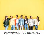 Small photo of Diverse community of young people smiling together on a yellow wall background - Multiracial college students having fun laughing outside - Youth culture concept