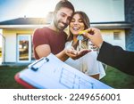 Small photo of Happy millennial couple receiving keys from realtor, purchasing real estate - Family meeting with real estate agent - New house and real estate concept