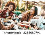 Small photo of Group of multi ethnic friends having dinner party in pub garden - Happy young people drinking wine and eating food sitting in bar restaurant table - Friendship, lunch break and youth culture concept