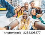 Multiracial best friends taking selfie walking on city street - Happy young people having fun enjoying day out - Diverse teens laughing at camera on summer vacation - Friendship and tourism concept