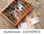 Small photo of Vintage wooden abacus and Russian currency, coins and banknotes, ready money.