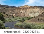 The John Day river flows by Cathedral Rock at the John Day Fossil Beds National Monument in Oregon, USA