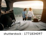 View Through the Car Trunk on Young Trendy Traveling Couple Having Fun Near the River Canyon Travel and Road Trip Concept