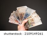 Small photo of the man holds a bundle of Croatian kuna banknotes in his hand. Concept showing Croatian economy and finance