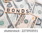 Small photo of flat lay photo showing us dollars and the word bonds. Bonds are a type of debt securities