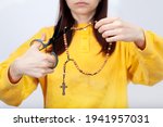 Small photo of The hands keep scissors on the rosary. The girl makes apostasy.