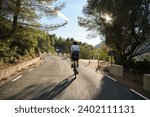 Small photo of Male cyclist is conquering the challenging uphill terrain on his gravel bike.Sportsman training hard on bicycle in the mountains..Man cyclist wearing cycling kit and helmet.Beautiful motivation image