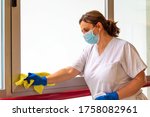 woman disinfecting hospital with mask and protection against coronavirus COVID-19
