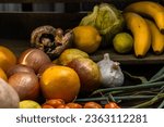 Small photo of Natural fruits and vegetables on a dark background, lettuce, lem