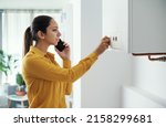 Small photo of Worried woman calling a boiler breakdown emergency service using her smartphone