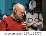 Humanoid AI robot taking care of a senior man at home and giving prescription medicines, healthcare and technology concept