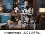 Smiling boy and AI robot playing video games together at home they are friends and giving a fist bump