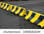 horizontal road marking lanes. highway concrete barriers on the road. vehicle collision lane separator. yellow color with black stripes. the road is not finished and ends in field concrete barriers