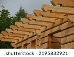 a carpenter built a log cabin with rough hewn beams. wood planing was not done before. authentic craftsmanship wooden log cabin. mortises for placing roof beams. gouging wood, ax, cut, truss, 