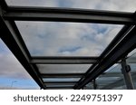 Small photo of strut, suspended glass roof above the building entrance. bus station, railway station. cable wind braces. aluminum construction with windows above pergola galvanized steel frame