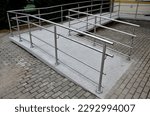 Small photo of the curved ramp at the entrance to the building is suitable for wheelchair access and supply to the building. stainless steel railing, concrete surface