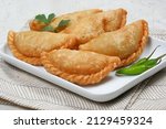 Small photo of Curry puff (kari pap) or Pastel Goreng is Pastry Popular in Indonesia. fried pastry with filling of sauteed vegetable , chicken and boiled egg. accompanied with sauce or raw chilli pepper