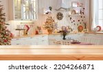 Small photo of Empty wooden table on background of light christmas kitchen in scandinavian style. Christmas background. Ready for product montage.Merry Christmas and Happy New Year! Banner.Mockup.