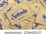 Small photo of Houston, Texas USA 12-04-2022: Splenda zero calorie sweetener packets scattered loosely. Global sugar substitute brand. Flat lay isolated macro image.